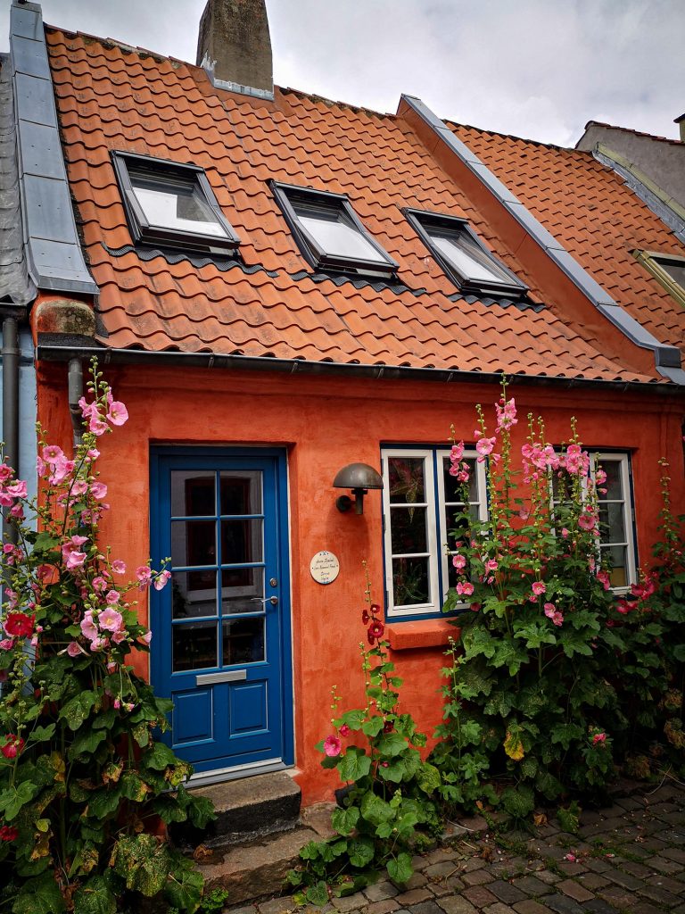 Maison rouge avec des fleurs et une porte bleue au Danemark